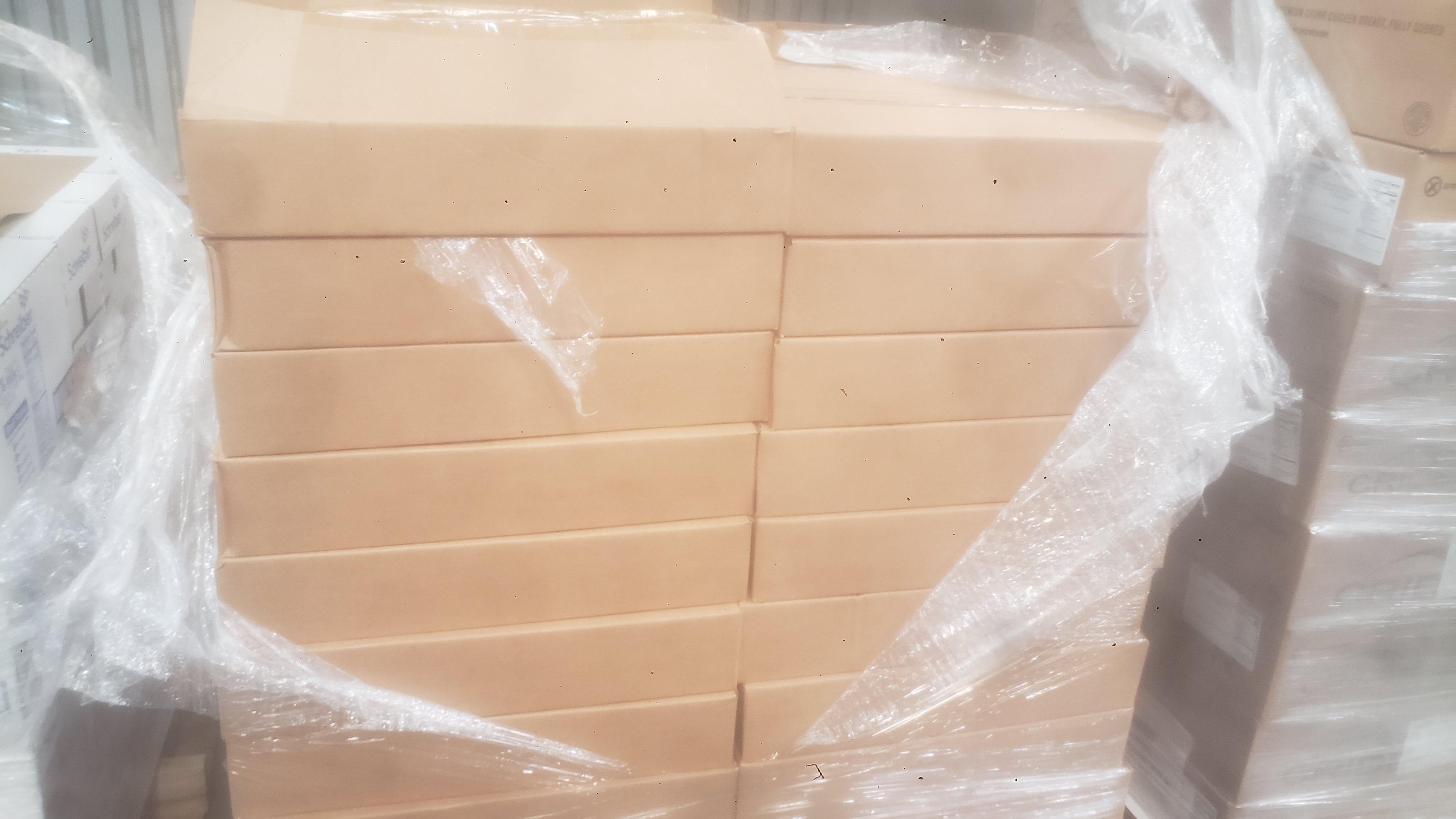 Cardboard boxes covered in plastic wrap and on a pallet.